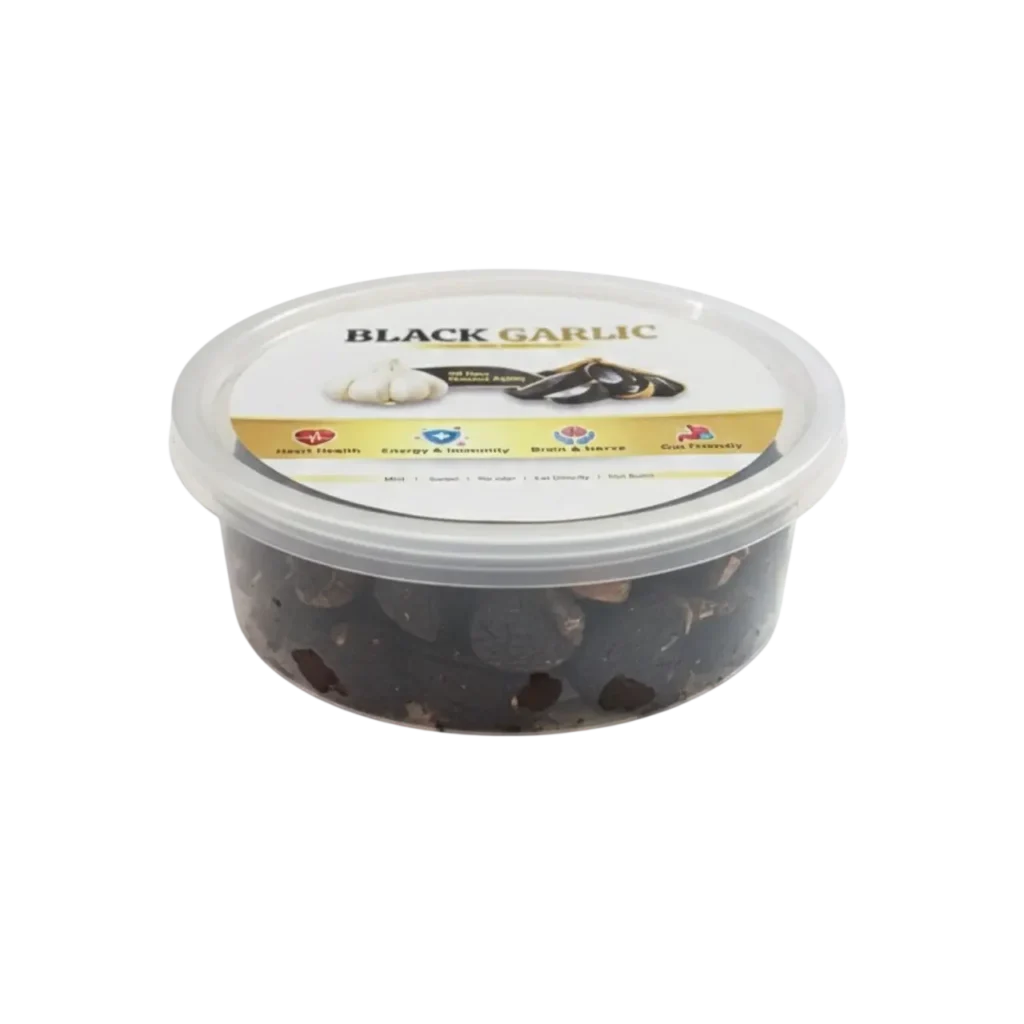 Whole fermented black garlic cloves in a clear plastic container, superfood for heart health and immunity.